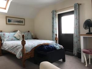 Schlafzimmer mit einem Bett und einem Fenster in der Unterkunft Oak Cottage in Llandysul
