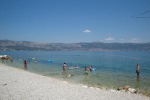 a group of people in the water at a beach at Apartments Marica in Trogir