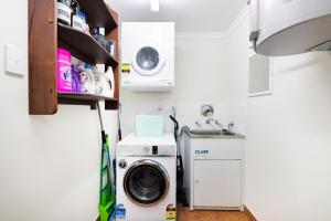 a small kitchen with a washing machine and a sink at ZEN FORESHORE Cozy 2-BR, 2-BA Holiday Home + Pool in Nightcliff