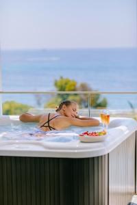 a woman laying in a jacuzzi tub at Ivi Mare - Designed for Adults by Louis Hotels in Paphos