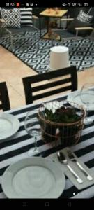 a table with white plates and a basket of greens on it at Vila LYDIA in Cambrils