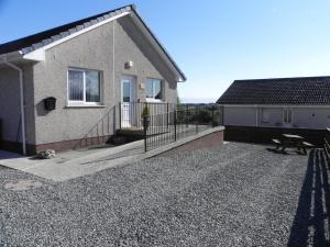 a house with a balcony and a bench in front of it at Tigh Murdag, 37D Newmarket HS2 0DT in Stornoway