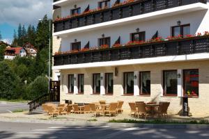 ein Gebäude mit Tischen und Stühlen davor in der Unterkunft Manor Ski Hotel in Predeal
