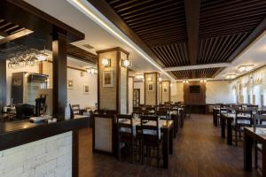 ein Esszimmer mit Holztischen und Stühlen in der Unterkunft Manor Ski Hotel in Predeal + 36 Fotos