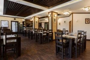 ein Esszimmer mit Holztischen und Stühlen in der Unterkunft Manor Ski Hotel in Predeal