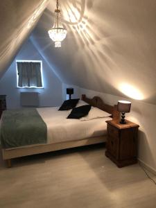a bedroom with a bed and a lamp on a table at Les appartements du Koifhus in Colmar