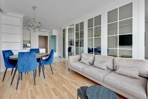 a living room with a couch and a table and chairs at Downtown Apartments Seaside Primore in Gdańsk