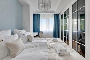 een slaapkamer met een groot wit bed en handdoeken bij Downtown Apartments Seaside Primore in Gdańsk