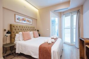 A bed or beds in a room at Maestranza Boutique