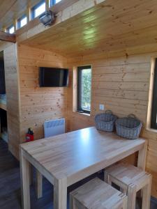 a dining room with a wooden table in a cabin at Eisenbahnromantik im Urlaub in Heinsdorfergrund