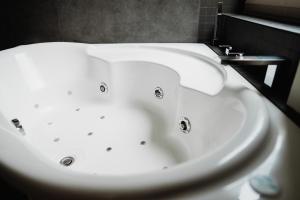 La salle de bains est pourvue d'une baignoire blanche et d'un lavabo. dans l'établissement Maison Durieux, à Limoges