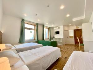 a room with three beds and a green couch at Barabulka Hotel in Sevastopol
