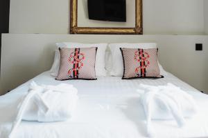 - un lit blanc avec 2 oreillers et des chaussettes blanches dans l'établissement Maison Durieux, à Limoges