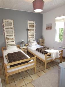 een slaapkamer met twee bedden in een kamer bij Maison Vert d'Eau in Grand-Village-Plage