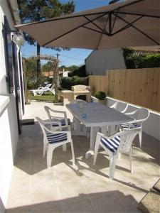 a table and chairs and an umbrella on a patio at Maison Vert d'Eau in Grand-Village-Plage