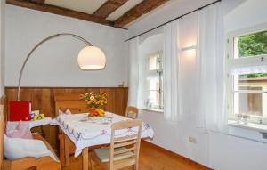 ein Esszimmer mit einem Tisch und 2 Fenstern in der Unterkunft Ferienwohnung Rothmhle in Schleyreuth