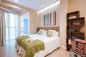A bed or beds in a room at Maestranza Boutique