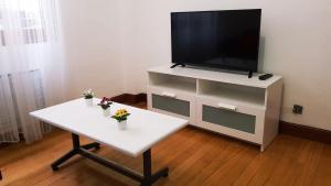 a living room with a white table and a tv at habitación, salita y baño privado, REATE LBI00466 in Bilbao