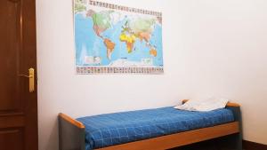 a bed in a room with a map on the wall at habitación, salita y baño privado, REATE LBI00466 in Bilbao