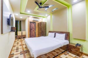 um quarto com uma cama e uma ventoinha de tecto em FabHotel GMC Grand em Lucknow