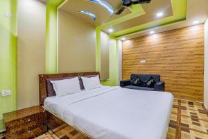 um quarto com uma cama branca e uma parede de madeira em FabHotel GMC Grand em Lucknow