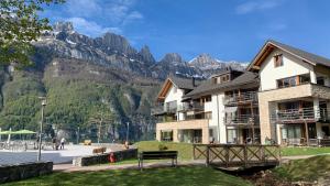 ein großes Gebäude mit Bergen im Hintergrund in der Unterkunft Luxuriöses Galerie-Penthouse direkt am Walensee in Unterterzen