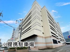 a large white building with writing on it at Hotel Trend Mikawaanjo in Anjomachi