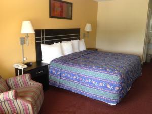 una habitación de hotel con una cama y una silla en Countryside Inn, en Wharton