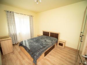 a bedroom with a bed and a window at L&R Modern Apartment in Oţelu Roşu