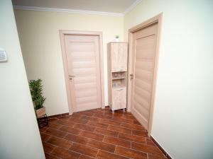 a hallway with two doors and a tiled floor at L&R Modern Apartment in Oţelu Roşu