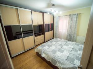 a bedroom with a bed and cabinets and a television at L&R Modern Apartment in Oţelu Roşu