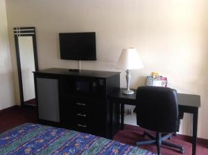 Un dormitorio con una cama y un escritorio con televisión. en Countryside Inn, en Wharton 1 foto más