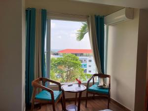 a room with a table and chairs and a window at SeaScape Port Blair in Port Blair