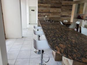 a kitchen with a counter with chairs and a counter top at Avonlea Guesthouse in Polokwane