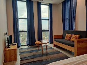 a bedroom with a couch and a table and windows at Tanzanite Apartment（Tanzanite Park） in Dar es Salaam