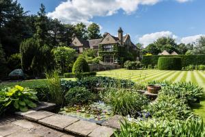 un jardín frente a una casa con un estanque en Fischers Baslow Hall - Chatsworth en Baslow