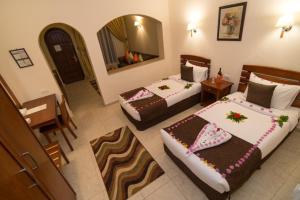 Tivoli Hotel Aqua Park في شرم الشيخ: غرفة فندقية بسريرين ومرآة