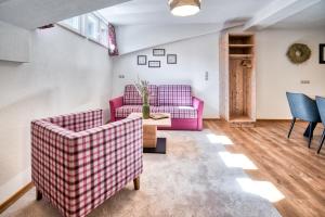 a living room with two pink couches and a table at Apart Fortuna in See