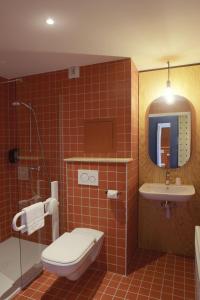 La salle de bains est pourvue de toilettes, d'un lavabo et d'une télévision. dans l'établissement Timberlodge, à Oz