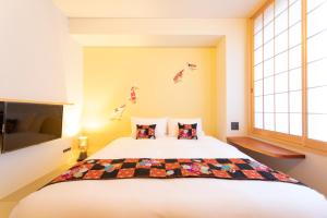 a bedroom with a large white bed and a window at Hotel Kanazawa Zoushi in Kanazawa