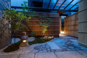 金沢市にあるHotel Kanazawa Zoushiの塀と消火栓を備えた日本庭園