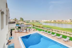 una vista aérea de una piscina en un hotel en Ultra Luxurious 9BR Villa in Emirates Hills by Deluxe Holiday Homes, en Dubái
