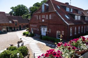 a large red brick building with flowers in front of it at Heide Hotel Reinstorf in Reinstorf