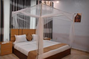 a bedroom with a bed with a canopy at Chimpanzee Lodge in Rwumba