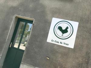 a sign on the side of a building with a chicken on it at Gîte Le Coq Au Vert en Suisse Normande in Hamars