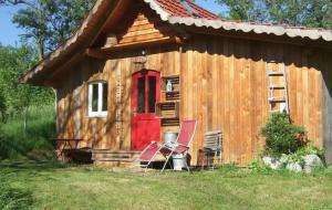 a log cabin with two chairs and a red door at Sonniges-naturnahes-Schwarzwald-Ferienhaeuschen in Welschensteinach