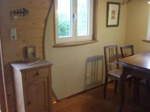 a dining room with a table and chairs and a window at Sonniges-naturnahes-Schwarzwald-Ferienhaeuschen in Welschensteinach