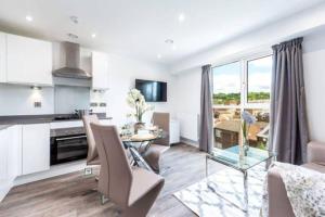 eine Küche und ein Wohnzimmer mit einem Tisch und Stühlen in der Unterkunft A beautiful brand new flat 25-minute to London in Luton