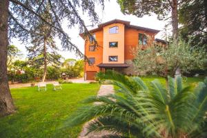 a house with two chairs in a yard at B&B Il Girasole in Corciano