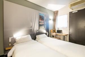 Un pat sau paturi într-o cameră la B&B HOTEL Grenoble Université